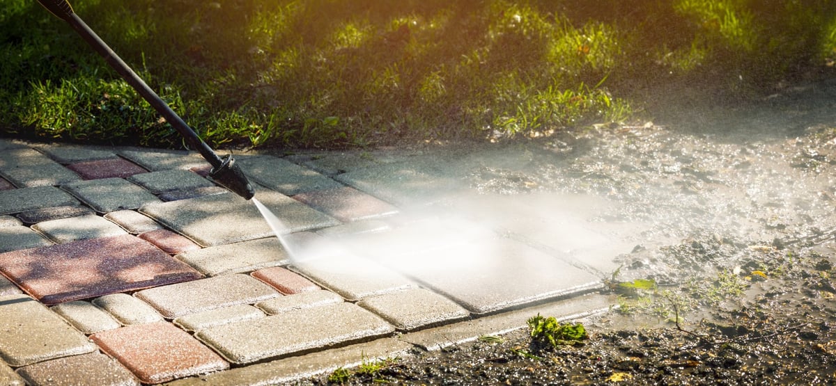 Dirty concrete driveway being pressure washed