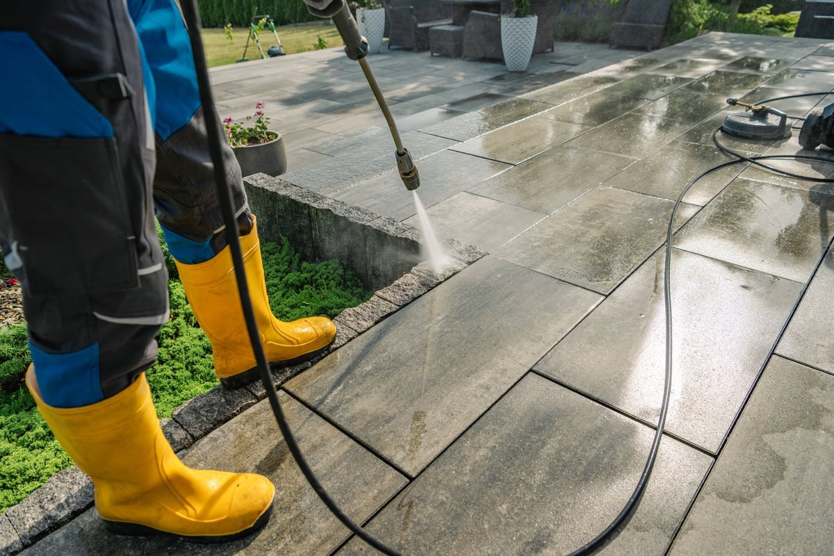 Professional pressure washing cleaning driveway and home exterior